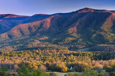 view of the church in cades cove and mountains from rich mountain road