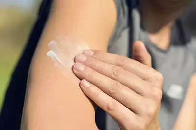 person putting sunscreen on themselves